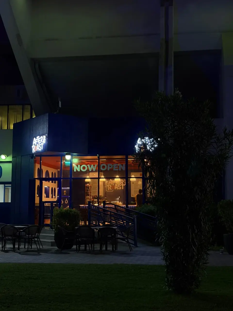 The After Roast storefront at night with a Now Open sign in the window